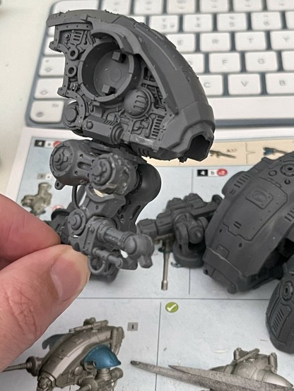 A partially constructed Warhammer Armiger model in a running pose.